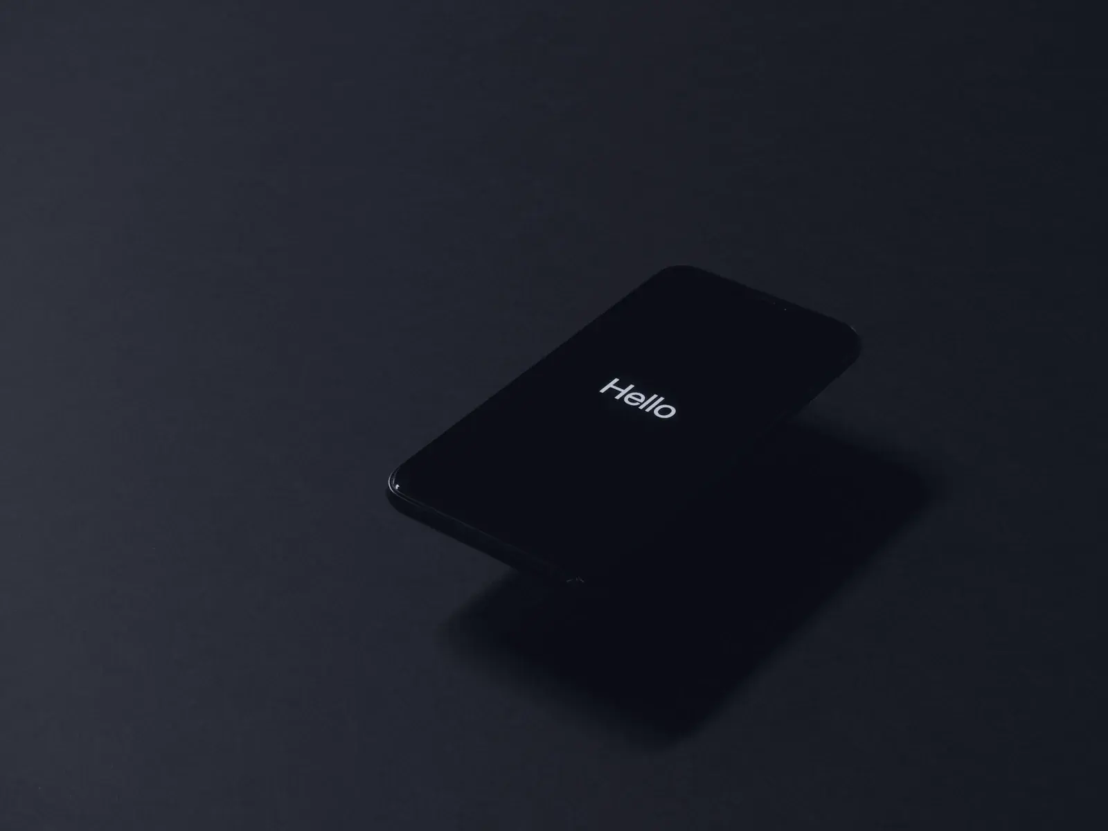 Smartphone allumé posé sur une surface sombre